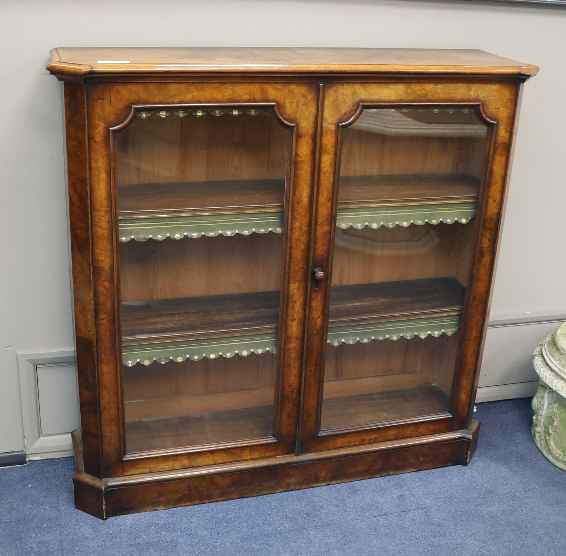 A Victorian walnut veneered bookcase with twin panelled glazed doors, length 126cm, depth 33cm, height 122cm